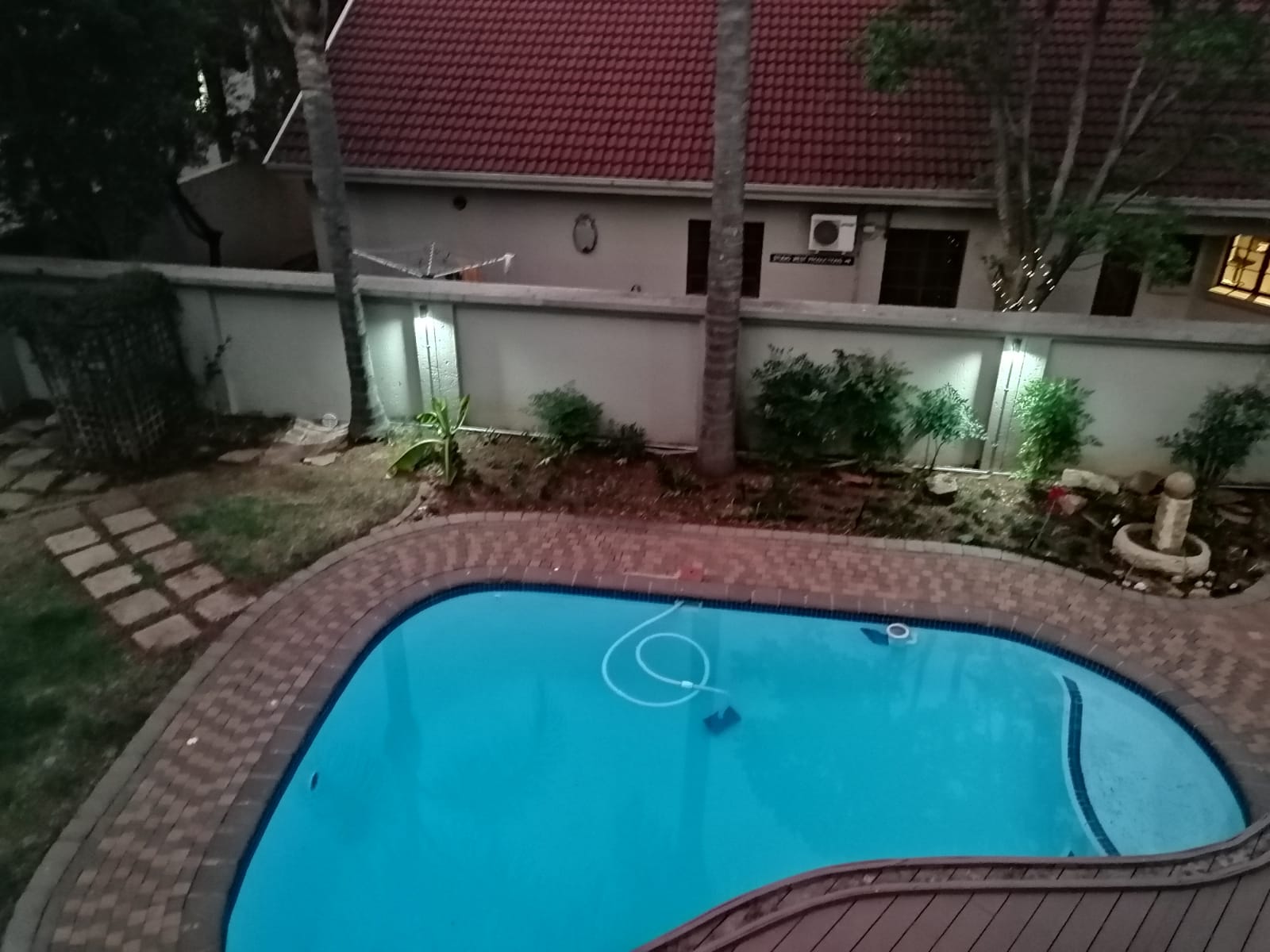 Security perimeter lights around a pool at dusk